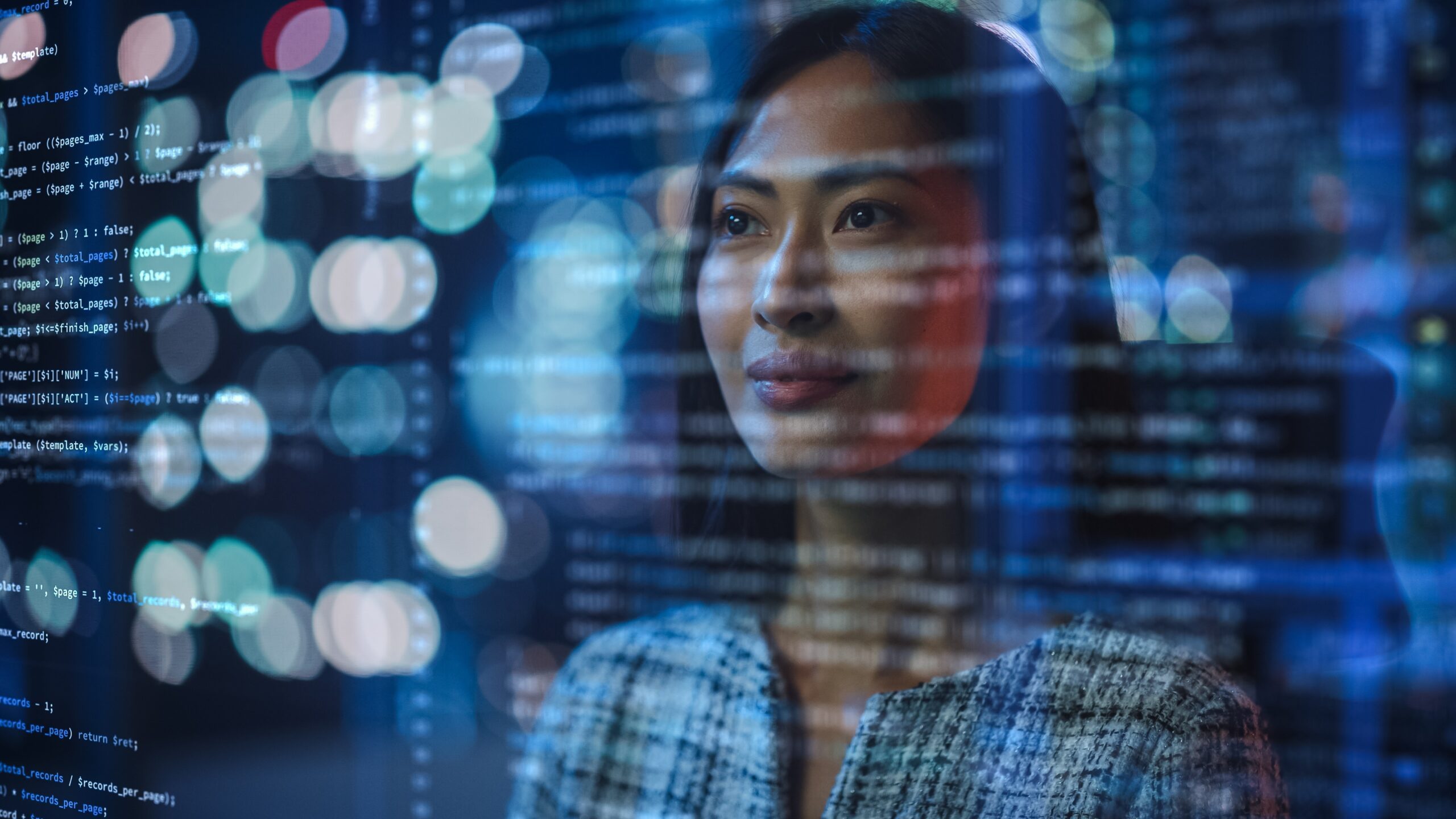 Woman looking at code on computer screen